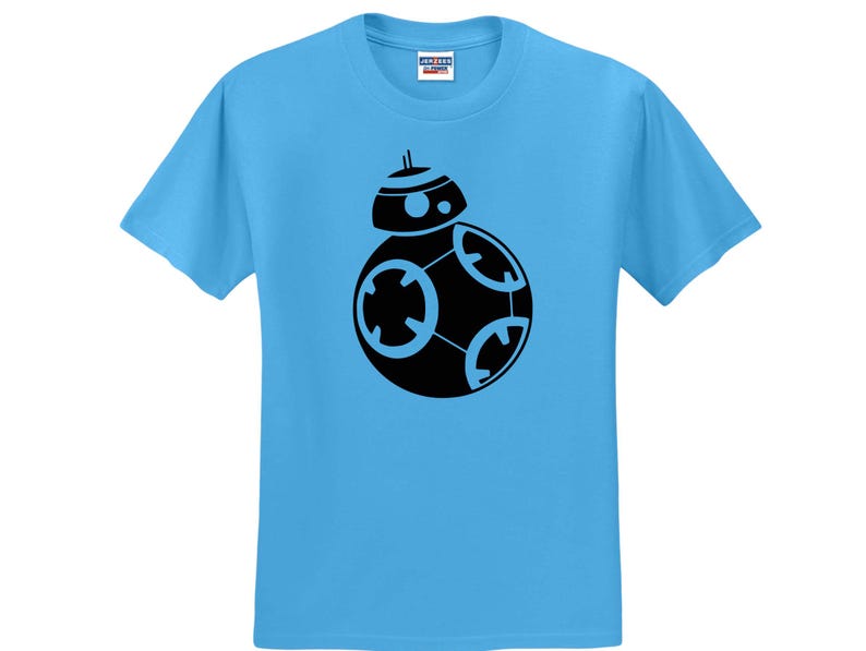 May include: A bright light blue short-sleeved t-shirt featuring a centered black graphic print of the BB-8 droid. The shirt has a crew neckline and a standard fit, with a small white brand label visible on the inside of the collar at the neck.