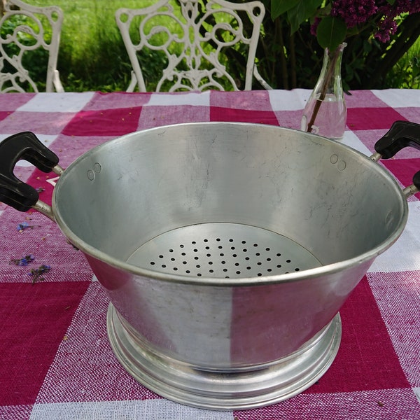 Old-fashioned aluminum French colander, classic kitchen gadget, feather-light, functional, simple. Old plastic handles. Vintage