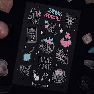 Puede incluir: Una tarjeta negra con ilustraciones blancas de un caldero, cristales, una botella de poción, un hongo y una taza. El texto "Trans Magic" está escrito en letras rosas y azules en la tarjeta.