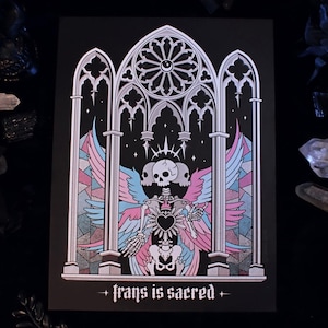 Könnte beinhalten: Ein schwarzer Druck mit einem Skelett mit Flügeln und einem Herzen, vor dem Hintergrund eines Buntglasfensters. Das Kunstwerk enthält den Text "trans is sacred" unten. Die Farbpalette umfasst Rosa, Blau und Weiß.