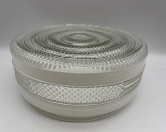 May include: A white glass ceiling light fixture with a textured, circular design. The fixture has a white frosted glass shade with a clear glass top.