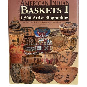 Puede incluir: Portada del libro "American Indian Baskets I" con el texto "1,500 Artist Biographies". La portada marrón muestra imágenes de diversas cestas tejidas. El libro forma parte de la "American Indian Art Series". Las cestas varían en forma y patrón.