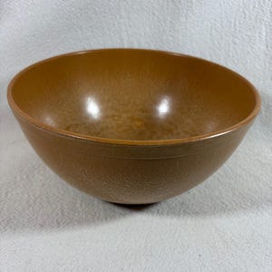 Pode incluir: Uma tigela de mistura grande de cor marrom com uma superfície texturizada.