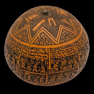 Puede incluir: Una calabaza con intrincados diseños negros grabados sobre una superficie marrón. La obra de arte incluye patrones geométricos, escenas con figuras y texto. La calabaza tiene forma redondeada y un fondo oscuro.