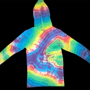 Puede incluir: Una sudadera con capucha de manga larga con estampado tie-dye de arcoíris. La sudadera tiene capucha y cordón. La tela es una mezcla de algodón suave y cómoda.