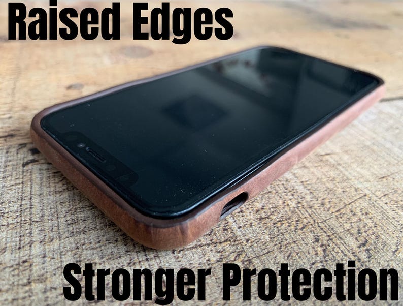 Peut inclure: Un smartphone dans une coque de protection en bois marron avec des bords sur&eacute;lev&eacute;s pour une meilleure protection. Le texte "Raised Edges" appara&icirc;t en haut &agrave; gauche et "Stronger Protection" en bas, soulignant la conception de la coque.