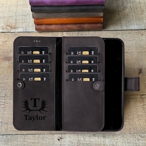May include: Dark brown leather phone case with multiple card slots and a snap closure. The case is open, revealing a black smartphone and several credit cards. The case is personalized with the name "Taylor" and a stylized "T" with antlers.