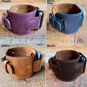 Peut inclure: Quatre bracelets de montre en cuir pour montres connect&eacute;es, pr&eacute;sent&eacute;s en violet, bleu roi, ambre et moka. Chaque bracelet pr&eacute;sente un design large avec des coutures blanches visibles, un passant en cuir assorti et une attache m&eacute;tallique.