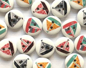 May include: Assortment of 20 wooden buttons with sailboat designs. The buttons feature various colors, including red, blue, green, yellow, and black. Each button has two holes for sewing.