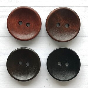 May include: Four wooden buttons with two holes each. The buttons are in two shades of brown and black.