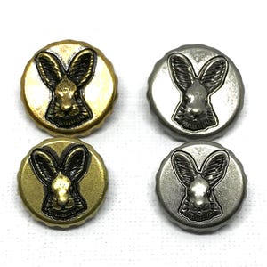 May include: Four metal buttons featuring a rabbit design. Two are gold-coloured, and two are silver. The rabbit is centrally placed, with long ears and a detailed face. Each button is approximately 2.5 cm in diameter.
