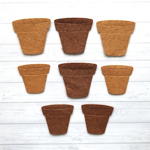 May include: Eight felt flower pots in two colours: brown and tan. The pots are arranged in three rows on a white wooden surface.