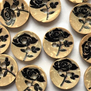 Puede incluir: Una colecci&oacute;n de botones de madera con un dise&ntilde;o de rosa negra. Los botones son beige con un patr&oacute;n de m&aacute;rmol marr&oacute;n claro.