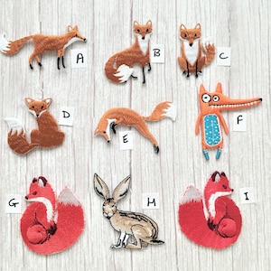 May include: Nine embroidered iron-on patches featuring foxes, a rabbit, and a cartoon monster. The patches are in various colours, including orange, red, brown, white, blue, and green. The patches are labelled with letters A through I.