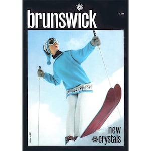 May include: Vintage magazine cover featuring a skier in a blue sweater, white pants, and red skis. The cover has the word "brunswick" in white and the text "new crystals". The skier is wearing a matching hat and goggles.