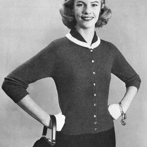May include: A gray cardigan sweater with a white collar and button closure. The sweater has long sleeves and a fitted silhouette.