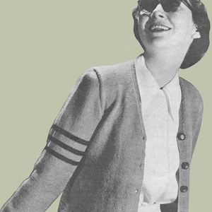May include: A gray cardigan with a white button-up shirt underneath. The cardigan has three black stripes on each sleeve. The person is wearing sunglasses and a beret.