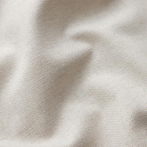 Può includere: Primo piano di un tessuto strutturato bianco sporco. Il materiale ha un aspetto tessuto con un motivo sottile di piccoli quadrati distanziati uniformemente. Il tessuto è leggermente stropicciato, creando ombre e variazioni di tono.