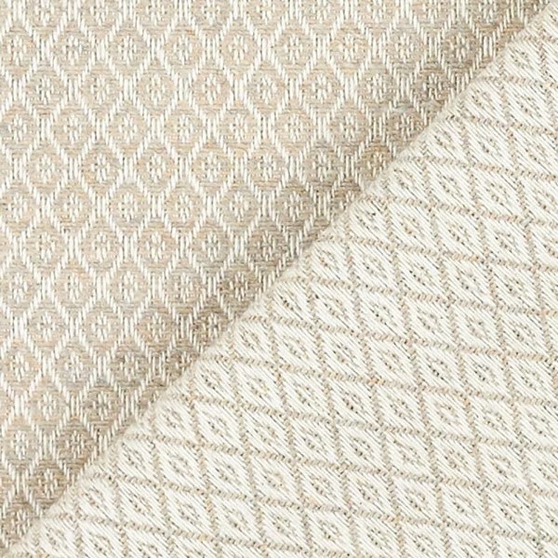 Puede incluir: Primer plano de una tela tejida con un patr&oacute;n de diamantes. La tela presenta tonos neutros de beige y blanco roto. El dise&ntilde;o de diamantes se crea mediante el tejido, creando una superficie texturizada.