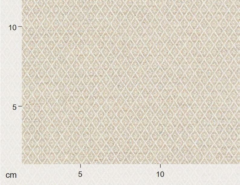 Puede incluir: Primer plano de una tela beige con un patr&oacute;n de diamantes. La tela tiene una apariencia texturizada y se mide en cent&iacute;metros. El patr&oacute;n de diamantes se crea mediante l&iacute;neas que se cruzan, formando un dise&ntilde;o geom&eacute;trico repetitivo.
