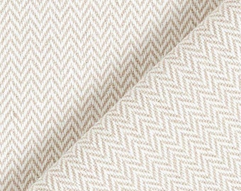 May include: Close-up of a beige and white herringbone weave fabric. The fabric is folded diagonally, revealing the texture and pattern. The weave creates a subtle, textured surface, suitable for upholstery or apparel.