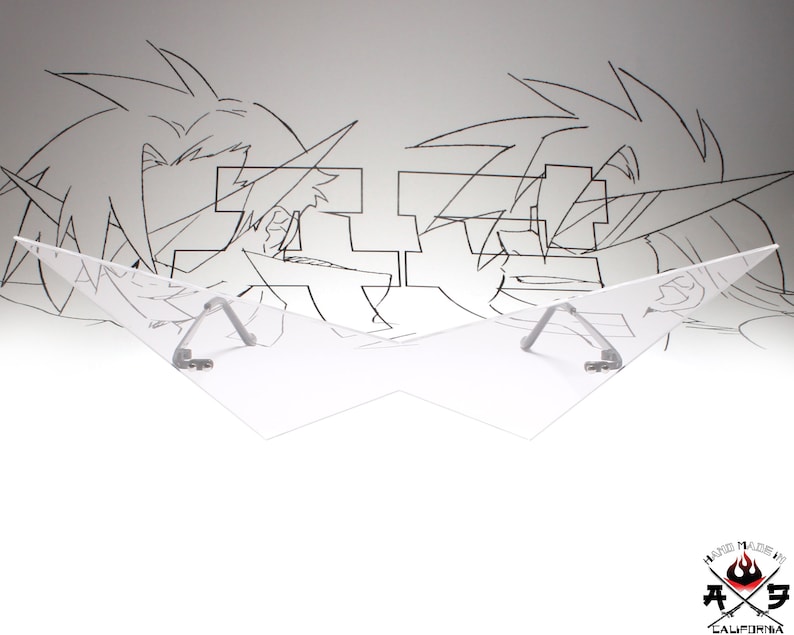 Puede incluir: Una visera de pl&aacute;stico transparente con dos soportes de metal plateado. La visera tiene forma de alas. La visera est&aacute; delante de un fondo blanco con un dibujo en blanco y negro de dos personajes de anime.
