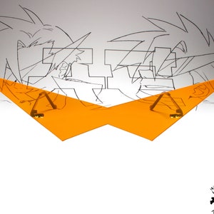 Puede incluir: Visera de pl&aacute;stico naranja con dos clips de metal dorado. La visera tiene forma de alas. La visera est&aacute; delante de un dibujo de dos personajes de anime.