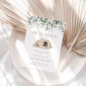May include: A white card with green watercolour leaves and a gold inscription that reads "He is Risen". The card also includes a watercolour illustration of a stone tomb with a rolling stone. The text below the illustration reads "Please join us for an Easter Brunch hosted by the Sunset Ward, Sunday April 02 at 9am. Please bring a special dish to share."