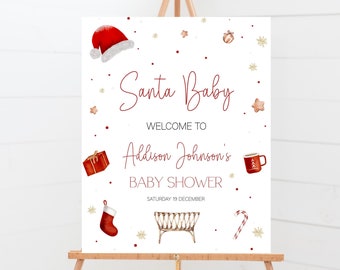 May include: A white sign with red and gold accents announcing a "Santa Baby" baby shower for Addison Johnson. The sign features a Santa hat, a gift box, a stocking, a crib, a candy cane, and a mug of hot chocolate.
