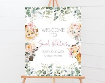 May include: Welcome to Sarah Miller's Baby Shower sign with a white background and floral greenery border. The sign features a lion, zebra, elephant, and giraffe with floral crowns. The text reads "Welcome to Sarah Miller's Baby Shower Saturday 19th April".
