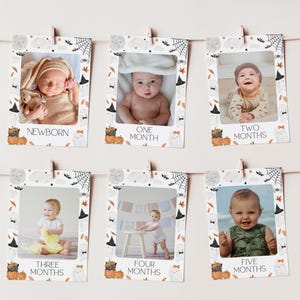 May include: A Halloween-themed baby milestone photo display. Each photo is framed with a decorative border featuring pumpkins, ghosts, bats, and spiderwebs. The photos are labeled with the baby's age in months, from newborn to five months.