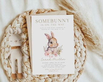 Pode incluir: Um convite para um chá de bebê com uma ilustração em aquarela de um coelho marrom com flores rosa. O texto diz "Somebunny is on the way" e inclui o nome "Sarah Miller" e os detalhes do evento.