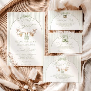 May include: Baby shower invitation suite with a soft, neutral color palette. The main invitation features the text "A Little Sprout Is On Her Way" with illustrations of baby clothes. Additional cards include "Books for Baby," "Diaper Raffle," and "Thank You."