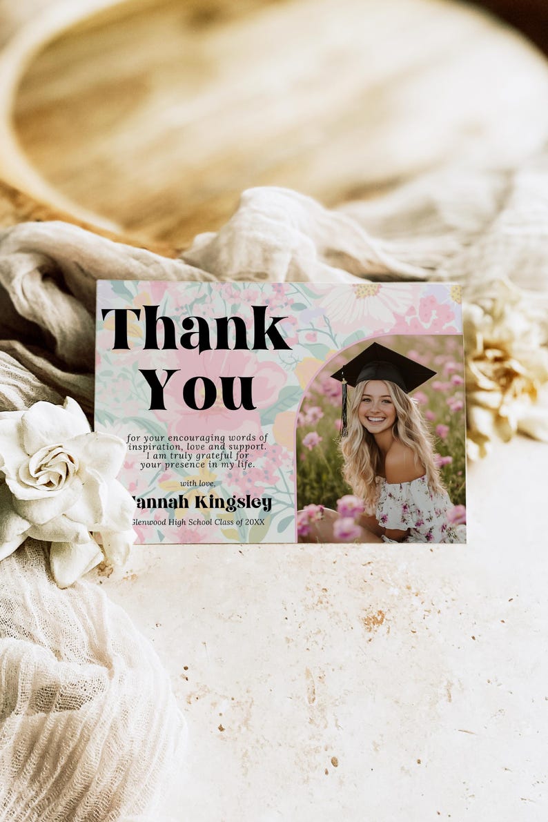 May include: A graduation thank you card with a floral design and a photo of a smiling graduate. The card reads "Thank You" in large black letters, with a personalized message and name.
