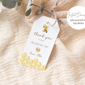 Könnte beinhalten: Ein weißes Dankeschön-Etikett mit einer Bienen-Illustration und einem Wabenmuster. Der Text lautet "Vielen Dank fürs Vorbeischauen love: Ella".