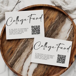 May include: Two white cards with the words "College Fund" in elegant script are displayed on a wooden tray. Each card includes a QR code and text: "If you wish to contribute to Sarah's college fund, please scan the QR code. Thank you for your love and support."
