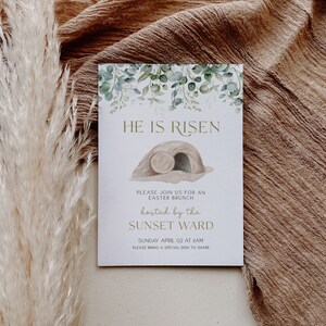 May include: A white card with green foliage and a gold inscription that reads "HE IS RISEN". The card also includes a drawing of a stone tomb with a rolled-away stone. The text below the drawing reads "PLEASE JOIN US FOR AN EASTER BRUNCH hosted by the SUNSET WARD SUNDAY APRIL 02 AT 11AM PLEASE BRING A SPECIAL DISH TO SHARE".