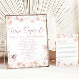 May include: A white card with pink floral border and the text "Time Capsule to be opened when Olivia turns sixteen."  The card has instructions for writing a message, memory, or prediction for Olivia to read when she turns sixteen.