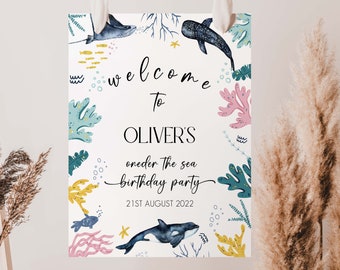 May include: A welcome sign for a child's birthday party with a nautical theme. The sign is white with blue, green, yellow, and pink watercolour illustrations of sea creatures, coral, and seaweed. The text reads "Welcome to Oliver's Under the Sea Birthday Party 21st August 2022".