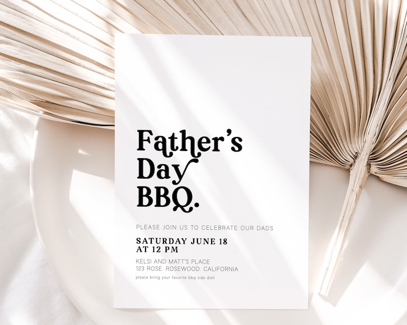 May include: A white Father's Day BBQ invitation with black text. The invitation includes the text "Father's Day BBQ" in a bold, decorative font, along with event details: date, time, and location. A dried palm leaf and a white plate are in the background.