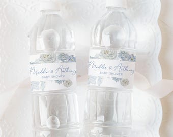 May include: Two clear plastic water bottles with blue and white floral labels that say "Maddie & Anthony Baby Shower".