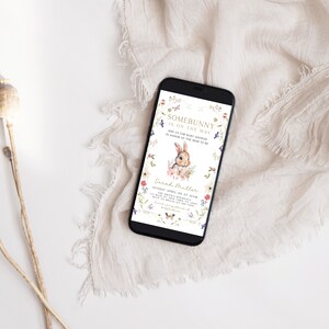 Puede incluir: Un tel&eacute;fono inteligente que muestra una invitaci&oacute;n a una fiesta de bienvenida al beb&eacute; con un borde floral y un conejito de dibujos animados. La invitaci&oacute;n dice "Somebunny is on the way" e incluye la fecha, la hora y el lugar del evento. El texto tambi&eacute;n incluye el nombre "Sarah Miller".