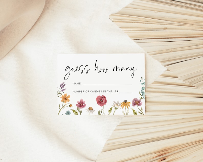 Op de afbeelding: Een witte kaart met de tekst "guess how many" in zwarte cursieve letters. De kaart heeft een bloemige rand met aquarelbloemen in tinten roze, geel, oranje en blauw. De kaart heeft twee lege regels voor een naam en het aantal snoepjes in een pot.