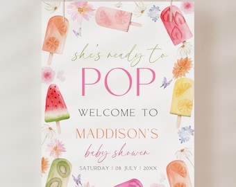 May include: A baby shower sign with a watercolour design. The sign reads "She's ready to POP" and "Welcome to Maddison's baby shower." The sign is decorated with popsicle illustrations and floral accents. The date is Saturday, 8 July, 20XX.