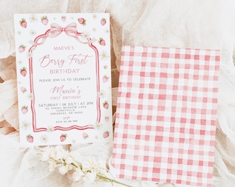 Peut inclure: Une invitation à motif vichy rose et blanc avec une bordure rose et un motif de fraises et de fleurs. L'invitation indique "Maeve's Berry First Birthday" et comprend les détails de la fête, y compris la date, l'heure et le lieu.