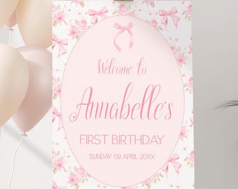 Peut inclure: Une pancarte d'accueil rose et blanche avec un motif floral et des nœuds roses. La pancarte indique "Bienvenue à Annabelle's First Birthday Sunday 09 April 20XX".