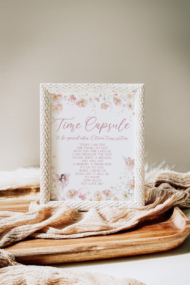 May include: A white frame with a floral design and the text "Time Capsule to be opened when Oliwia turns sixteen." The text inside the frame reads: "Today I am one. Time passes so fast. With this time capsule I can treasure the past. Please write a message. Any will do. A memory, a prediction. It's up to you. When I grow up what gift it will be. To know how much you love me!"