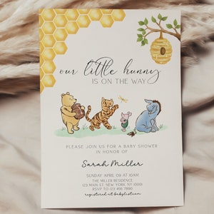 May include: A Winnie the Pooh themed baby shower invitation featuring a yellow honeycomb pattern, a beehive, and illustrations of Winnie the Pooh, Tigger, Piglet, and Eeyore. The text reads "our little hunny is on the way".