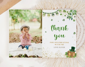May include: A thank you card with a green shamrock and gold pot of gold design. The card says "Thank you for celebrating with me, Love Oliver". A photo of a baby boy wearing a hat is in the background.