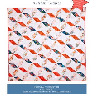 May include: A quilt pattern called "Susie B" by Penelope Handmade. The quilt features a geometric design with red, white, and blue fabric. The pattern is available in euro, baby, throw, and bed sizes.